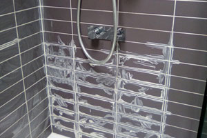 before image of re-grouting and caulking around bath tiles to reseal.